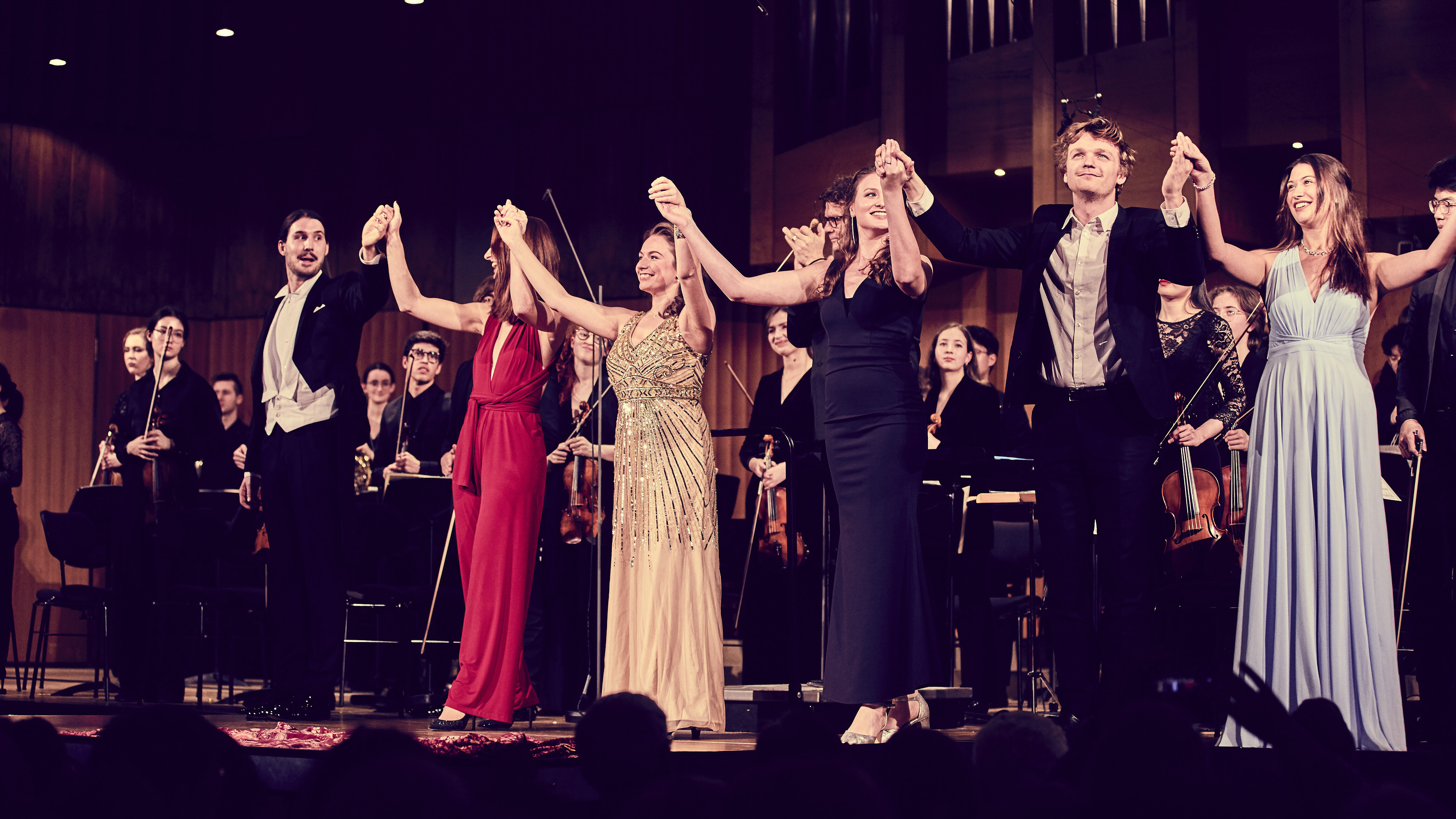 Music performers holding hands in a curtain call at the New Year's Concert of the HMTM