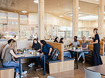 Groups of students dine in the modern cafeteria of Landshut UAS