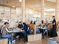 Groups of students dine in the modern cafeteria of Landshut UAS