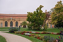 Grüner Park mit Orangerie im Hintergrund
