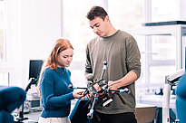 Zwei Studenten betrachten eine roboterähnliche Maschine