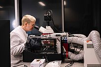 A researcher looking through a microscope