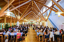 Many students sitting in a refectory eating and chatting