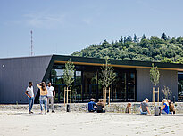 Several groups of students talk on the campus of Landshut UAS