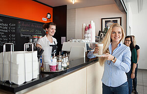a student taking a cup of coffee in a bar