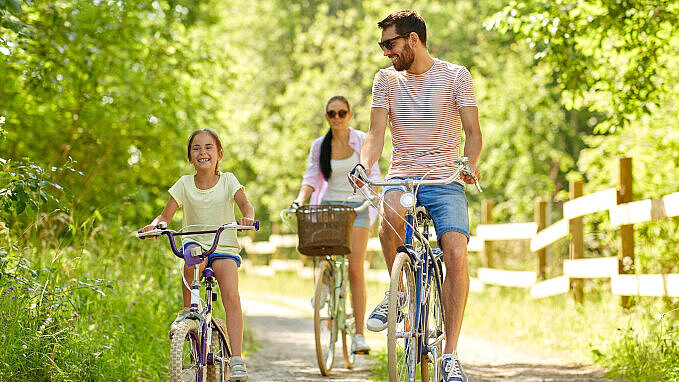 Parents and their child riding their bikes.