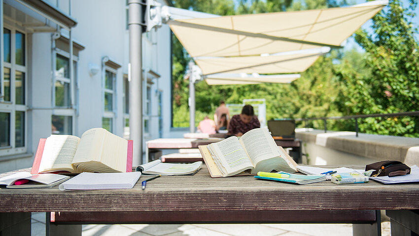 Bücher auf einem Tisch vor der Uni