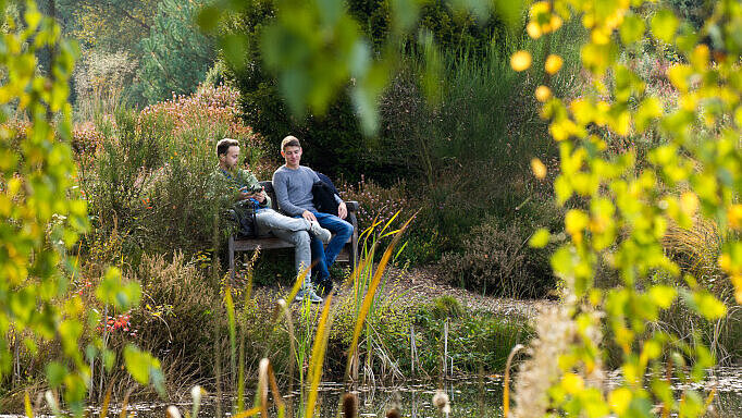 Two students sitting outside on Campus.