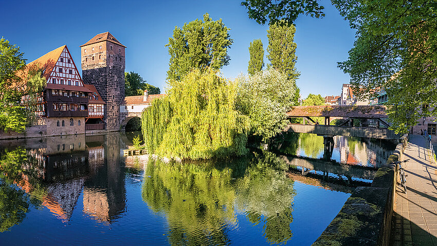 View of a part of the Pegnitz river in Nuremberg: the Henkerturm and Henkersteg along with a traditional house from the middle ages in the style of Fachwerkshaus