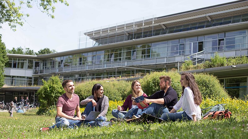Studierende vor einem Hochschulgeb&auml;ude
