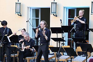 S&auml;nger w&auml;hrend des Popkonzerts mit Bigband im Hintergrund