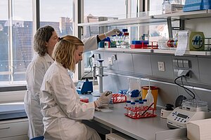 Research Teaching in Erlangen @Anna Tiessen Two female women in lab coats work in a modern laboratory