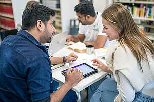 © Benjamin Herges Three students work in a small group around a small table