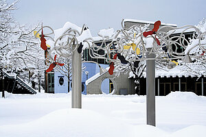 @ Uni Augsburg Künstlerische Springbrunnen auf einem schneebedeckten Campus im Winter
