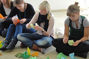 @ Hochschule München Students working with Origami in a seminar.