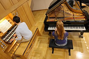 Zwei Studenten, die an Klavier und Orgel spielen