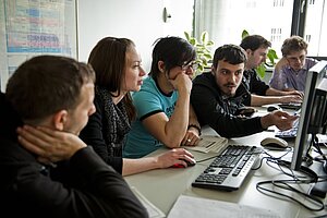 @ Hochschule München Students exchange ideas in a computer room.