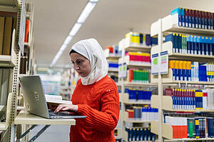 © Benjamin Herges A female student works on a laptop in a library