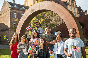 © Benjamin Herges A diverse group of students waving flags of their origin country on the campus of the University of Bamberg
