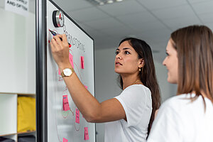 Zwei Studentinnen an einem White Board.