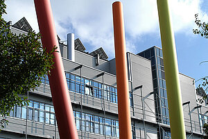 @ Uni Augsburg Riesige Stangen in jeweils von links nach rechts rot, orange, grün