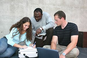 @ Hochschule München Three international students working on a project.
