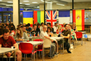 @ UR eine Gruppe Studierender feiert vor den Flaggen verschiedener Länder.