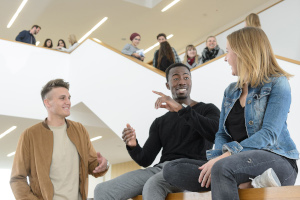 Studierende im Teppenhaus eines Hochschulgebäudes